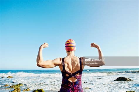 Older Caucasian Woman Flexing Her Muscles On Beach Bildbanksbilder