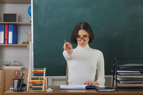 Premium Photo Strict Young Female Teacher Wearing Glasses Points At