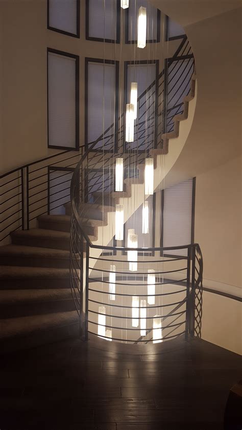 A Spiral Staircase Is Lit Up With Light From The Windows On Either Side