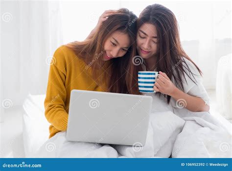 Asia Lesbian Lgbt Couple Sitting On Bed Hug And Using Laptop Com Stock