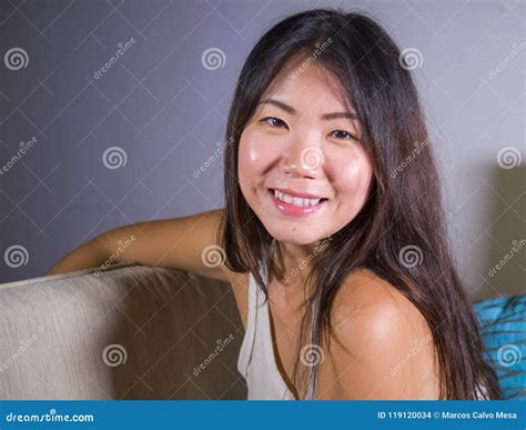 Lifestyle Close Up Portrait Of Young Beautiful And Happy Asian Chinese Woman Lying At Home Sofa