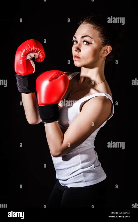 Beautiful Young Woman In A Red Boxing Gloves Over Black Background