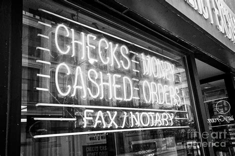 Neon Sign In A Store Window For Checks Cashed Or Money Orders And Fax