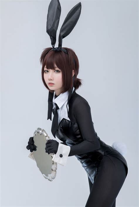 A Woman Dressed In Black And White Holding A Mirror With Bunny Ears On