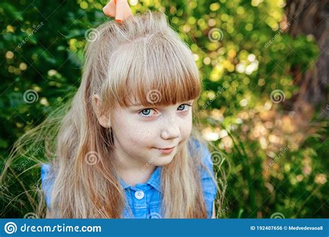 Charming Little Girl With Blue Eyes And Long Golden Hair