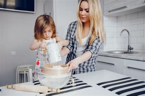 Una Hermosa Joven Madre Con Su Pequeña Hija Está Cocinando En La Cocina