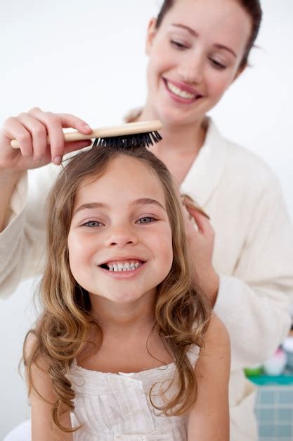 premium photo portrait of mother doing her daughter s hair