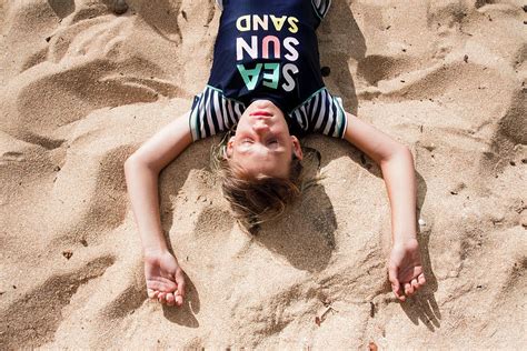 Girl Laying On The Velzyland Beach In Hawaii Photograph By Cavan Images Pixels