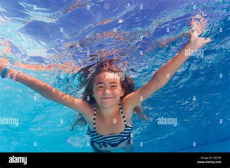 Beautiful Preteen Girl Enjoying Swimming Under Water Of The Pool Stock