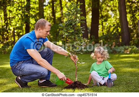 Father And Boy Planting Tree Father And Small Boy Planting Tree In