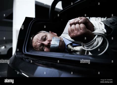bound and gagged a frightened businessman lying bound and gagged in the boot of his car stock
