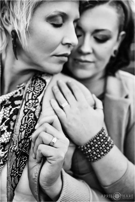 bandw romantic photo of a close up of the engagement rings on a lesbian couple s fingers during