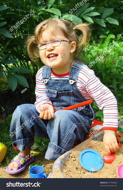 Adorable Little Girl 2 Years Old Wearing Glasses In Jeans Overalls