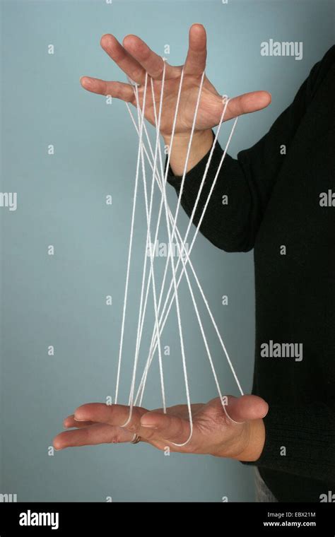 Person Doing A Game Of Skill With Threads Spanned Between The Hands