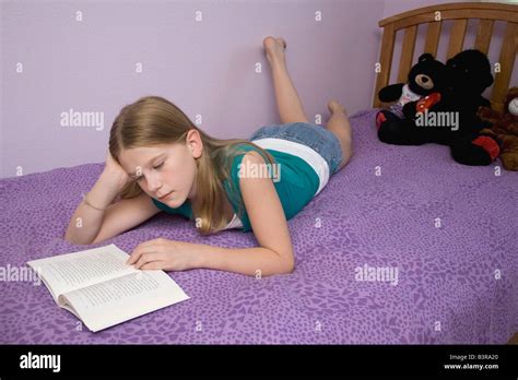 Niña Acostada En La Cama En Su Estómago Leyendo Un Libro Fotografía De Stock Alamy