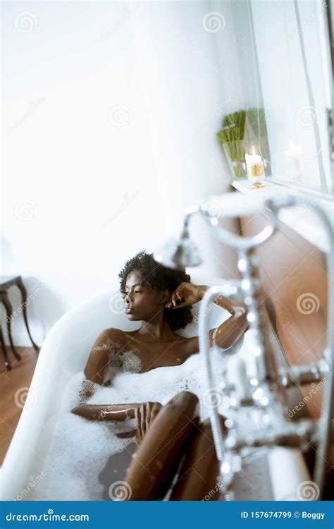 Beautiful African American Woman Bathing In A Tub Full Of Foam Stock