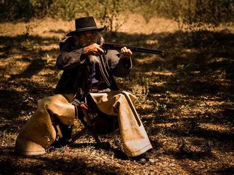 A Senior Cowboy Sat With A Gun To Guard The Safety Of The Camp In The