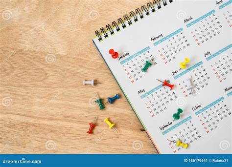 Push Pins With White Yearly Calendar On Wooden Table Stock Image