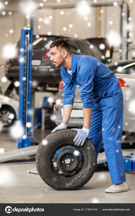 Auto Mechanic Changing Car Tire At Workshop Stock Photo By ©syda