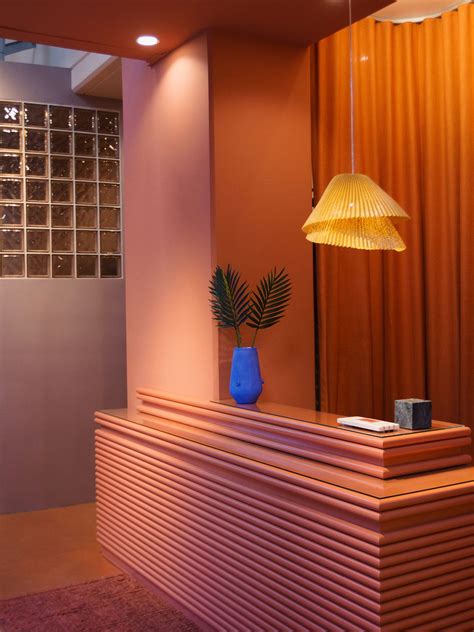 a reception desk with a blue vase on top and a yellow lamp hanging over it