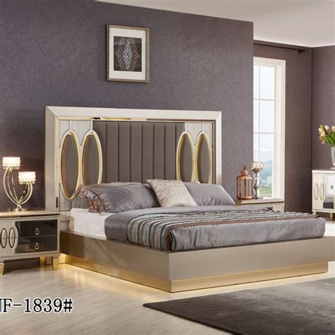 A Bed Room With A Neatly Made Bed And Dressers