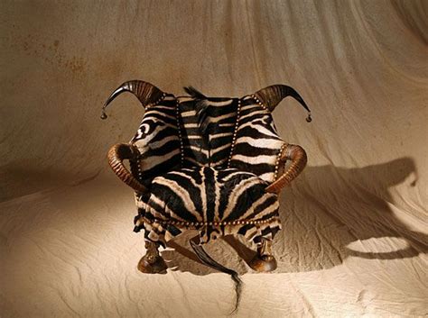 A Zebra Sitting On Top Of A Wooden Chair In The Middle Of A White Room