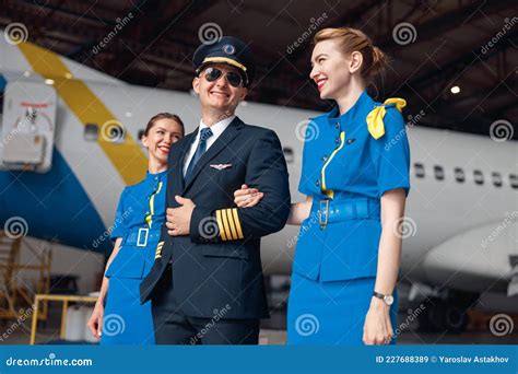 Smiling Pilot In Uniform And Aviator Sunglasses Walking Together With