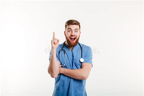 Excited Young Male Doctor Pointing Finger Up At Copyspace Stock Photo