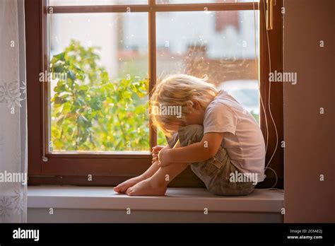 Abandoned Little Toddler Boy Sitting Sad On A Window Shield Looking