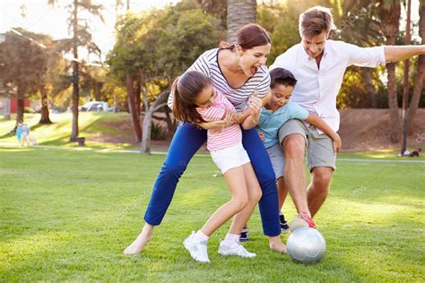 Familia jugando al fútbol en el parque Foto de stock 50697379