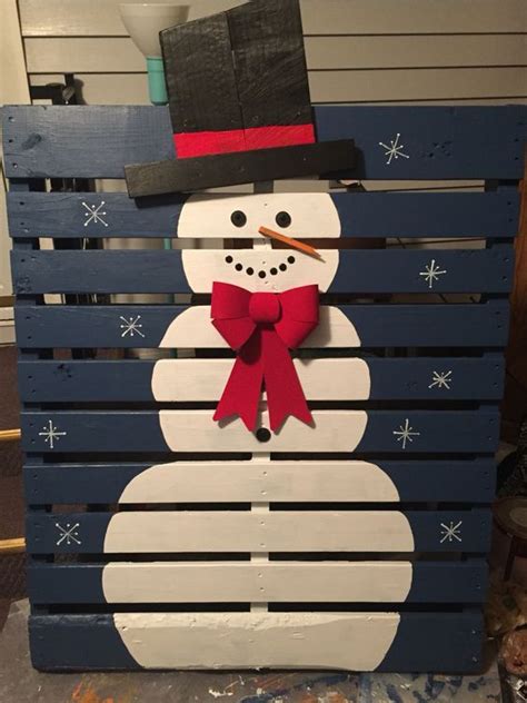 A Snowman Made Out Of Pallet Boards With A Top Hat And Red Bow Tie