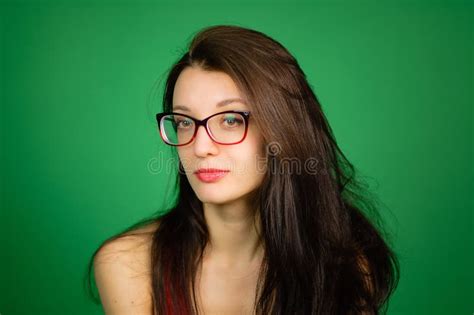Studio Portrait Of Cute Smart Girl In Eyeglasses And Red Top On Green