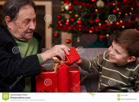 Grandchild Giving Christmas Present To Grandfather Stock Photo Image