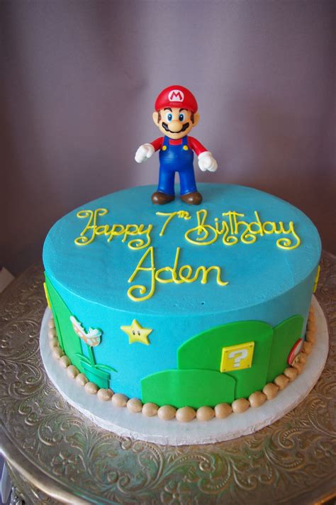 A Blue Birthday Cake With A Mario Figure On Top