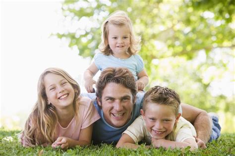 Familia Que Miente Al Aire Libre Sonriendo Foto De Archivo Imagen De