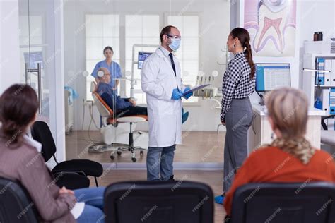 Médico Dentista Interrogando A La Mujer Y Tomando Notas En El