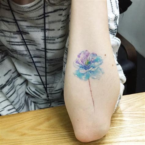 Simple Tiny Watercolor Like Colored Flower Tattoo On
