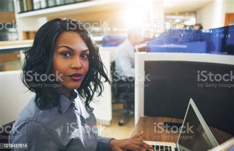 Young Businesswoman Working On A Laptop In Her Office Cubicle Stock