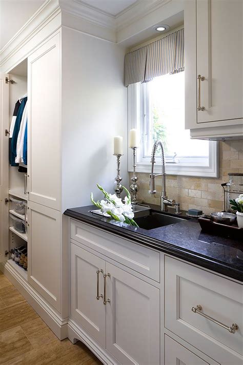 Repeat the above process 24 inches out from the wall as well, running the straight edge or level parallel to the wall where the front of the cabinets will sit. white laundry room with black marble countertop and sink ...