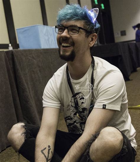 A Man With Blue Hair Sitting On The Floor