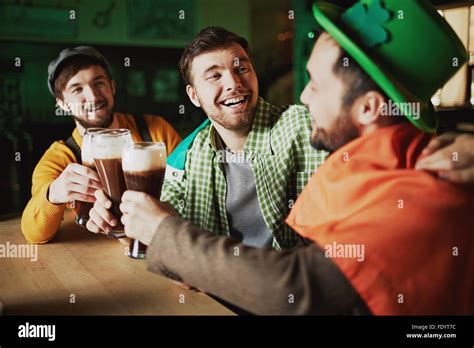 Multi Ethnic Young Men Drinking Beer And Relaxing In Pub Stock Photo