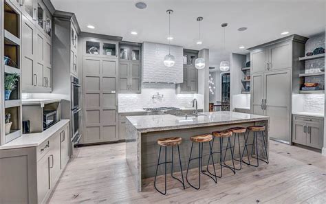 Everyone needs a retreat from reality. Contemporary kitchen with light gray cabinets, light wood floors and white textured backsplas ...