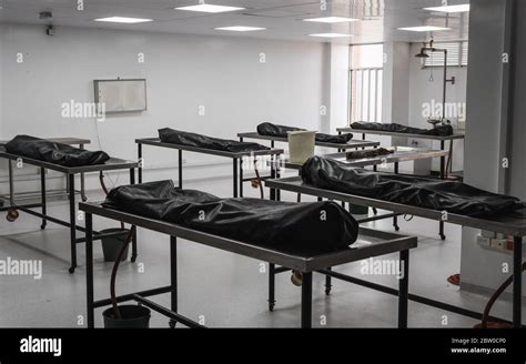 Covered Human Corpses On Tables In A Morgue Mortuary Waiting For
