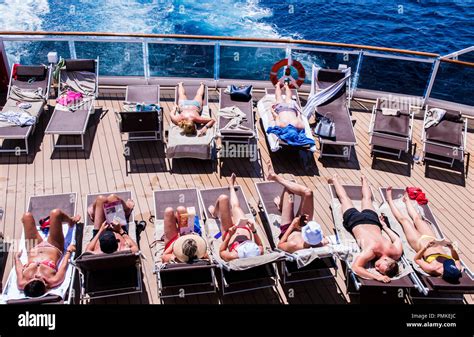 elevated view of cruise guests sunbathing and reading on deck of cruise ship msc seaview stock