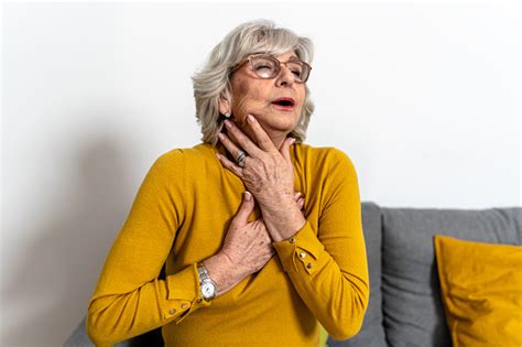 A Senior Woman Is Experiencing Everyday Pain In Her Throat Due To
