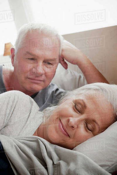 Senior Man Looking At Sleeping Wife In Bed Stock Photo Dissolve