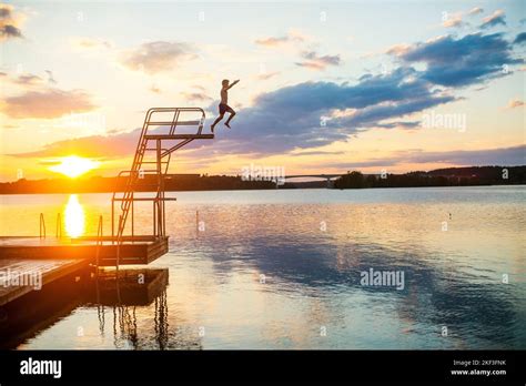 Boy Diving Into Lake At Sunset Stock Photo Alamy