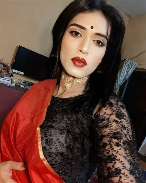A Woman With Long Black Hair Wearing A Red And Black Sari Posing For