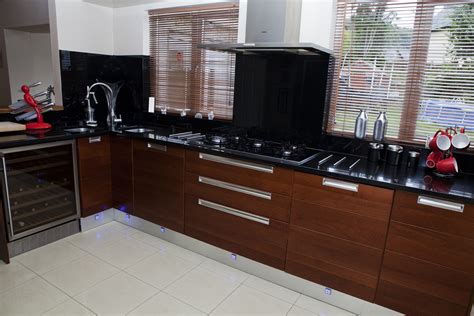Take a look at howdens for kitchen ideas the wall units are fitted with rippled glass and satin brass flush rings. High Gloss Cream and Walnut Contemporary Kitchen | Parle ...