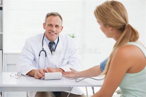 Smiling Doctor Taking Patients Blood Pressure Stock Image Image Of